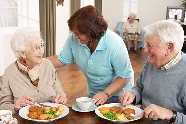 Senior Couple Being Served Meal at Comfort Cove Assisted Living